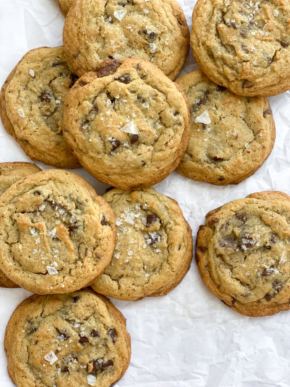 a bunch of salted chocolate chunk cookies stacked on top of each other.