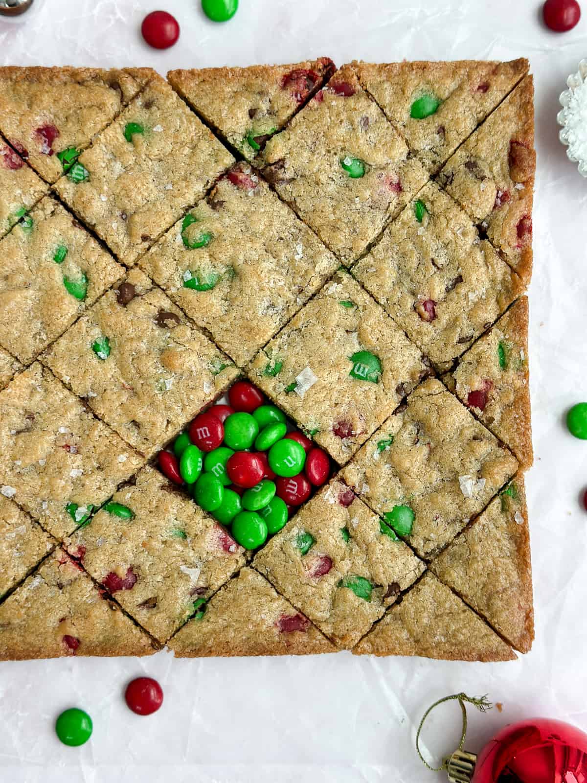 a close up of the chewy christmas blondies with some holiday m&m's.