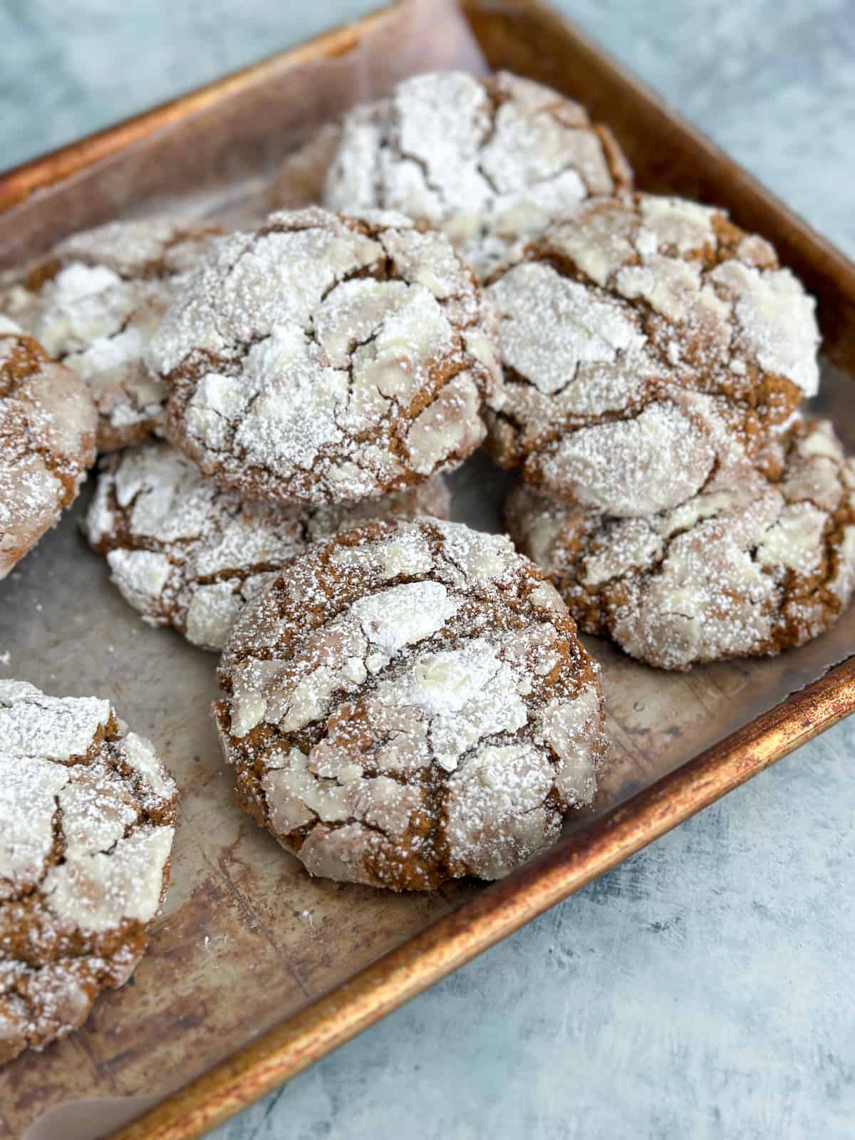 a stack of molasses crinkle cookies on a baking sheet.