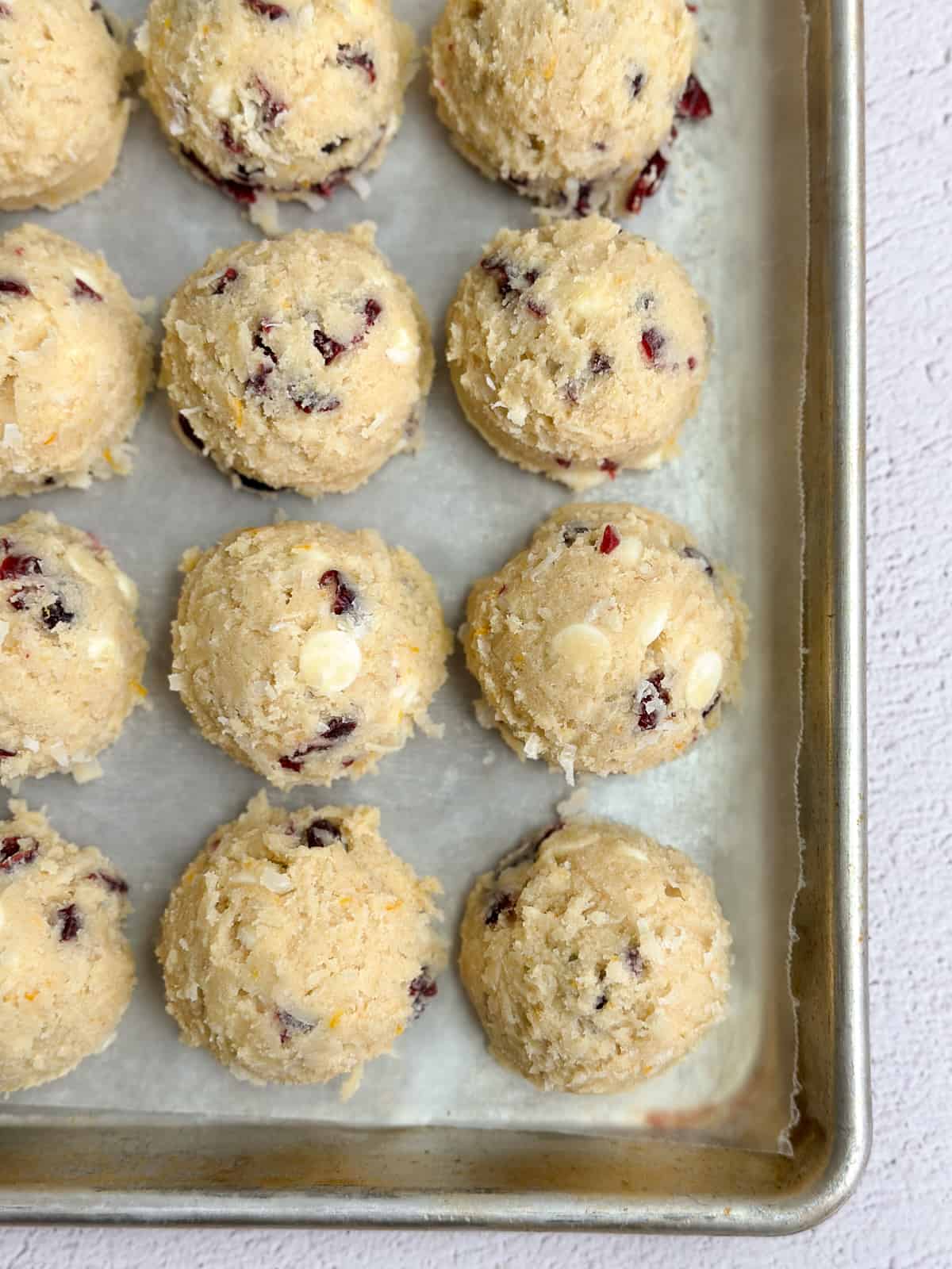 a bunch of the white chocolate orange cranberry cookie dough lined up.