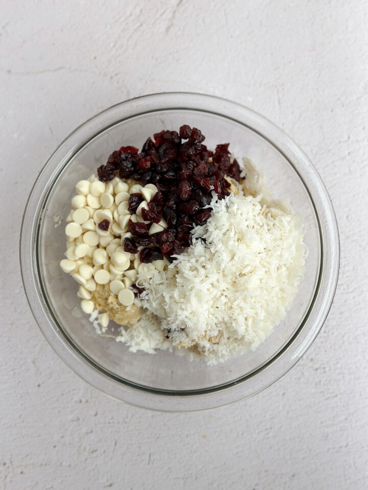 adding in the white chocolate, cranberries and coconut.