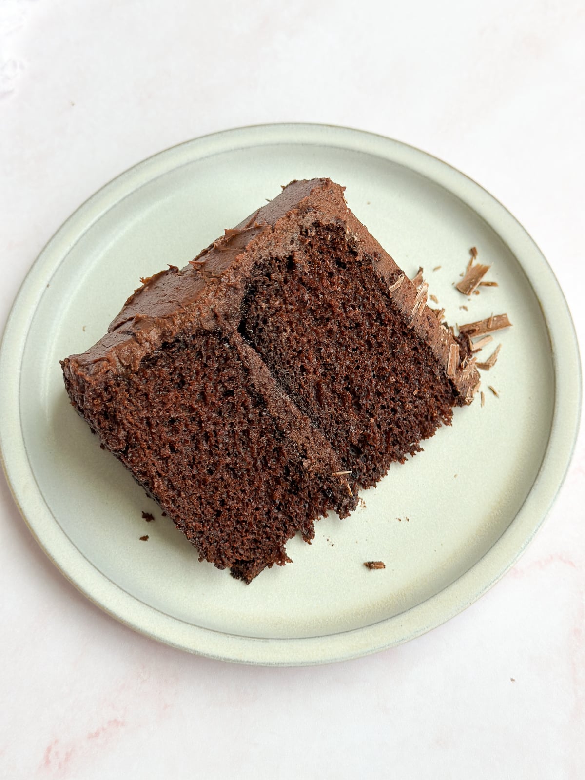 A slice of small chocolate cake on a plate.
