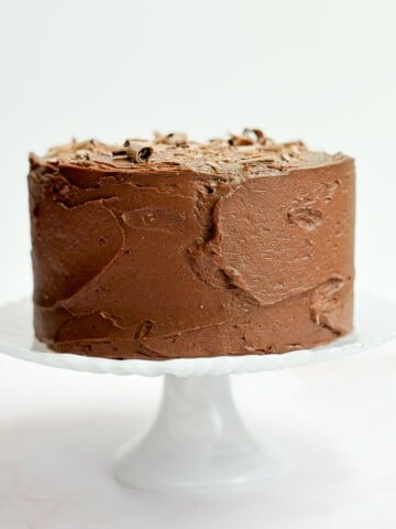 The whole small chocolate cake on a cake stand before cutting.