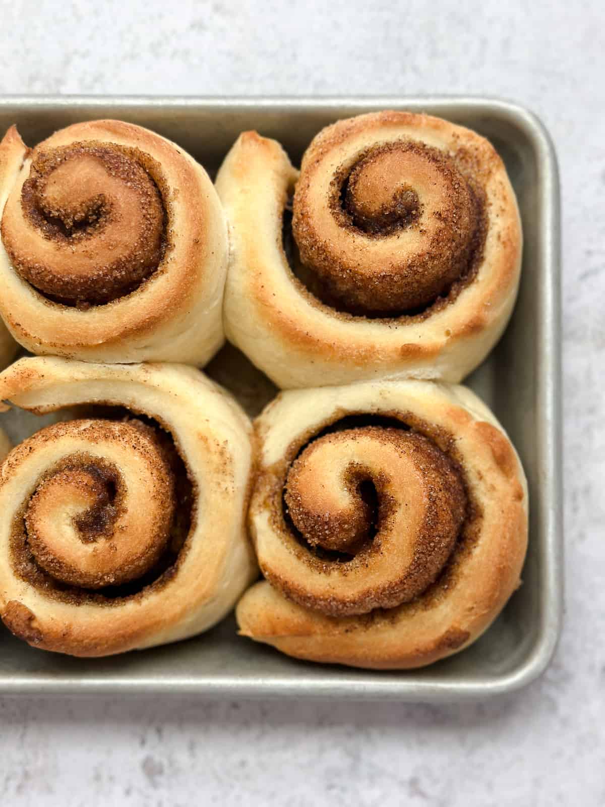 showing a few of the small batch cinnamon rolls in the pan right out of the oven.