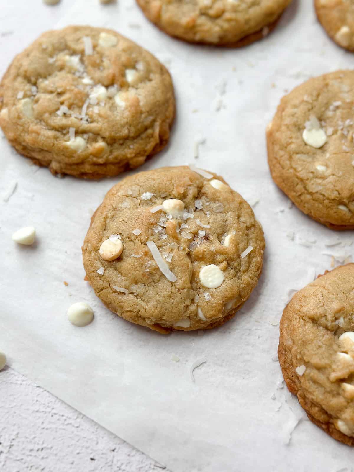 quelques biscuits à la noix de coco et au chocolat blanc sur un morceau de papier sulfurisé.