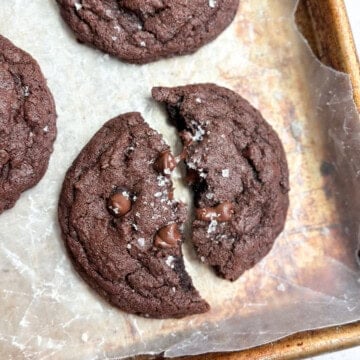 a single small batch chocolate cookie broken in half.