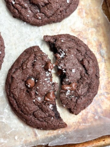 a single small batch chocolate cookie broken in half.