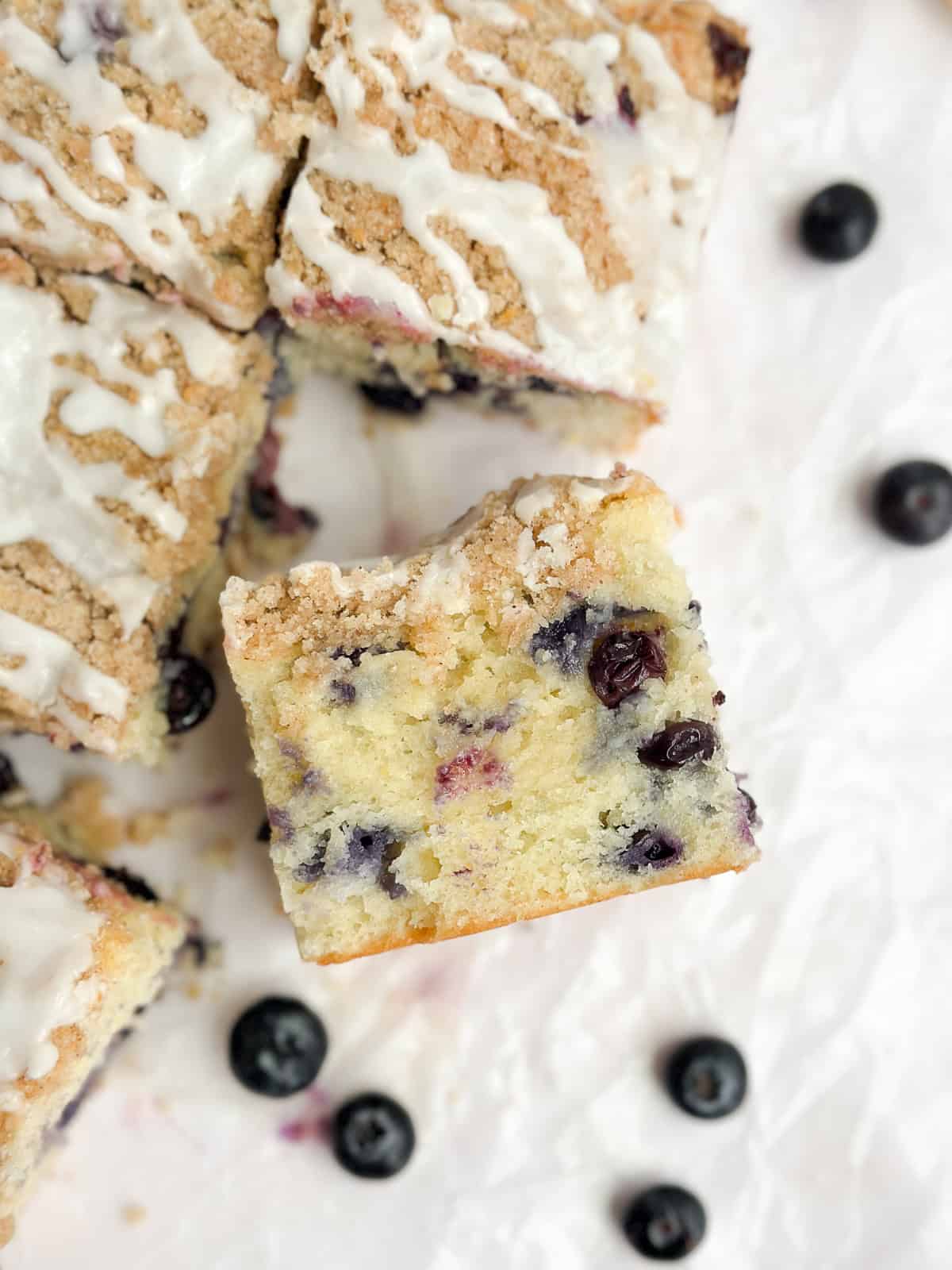 une tranche de gâteau aux myrtilles et au citron découpée pour voir l'intérieur.