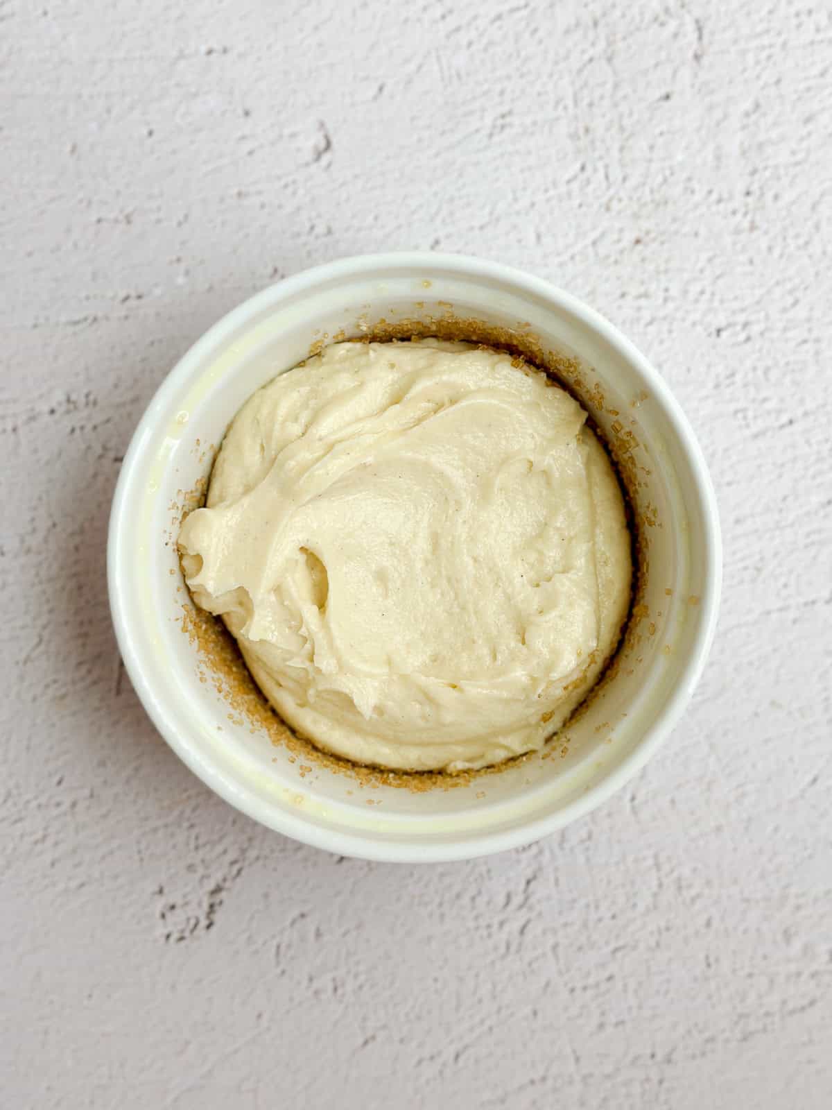 a ramekin with the butter cake batter inside.