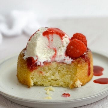 a butter cake on a plate with a bite missing to see inside.
