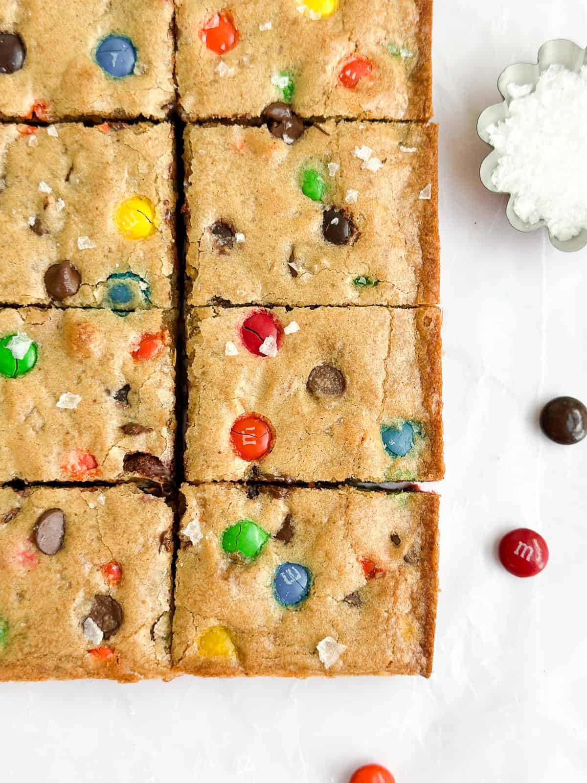 a close up of the browned butter m&m blondies with a little salt on the side.