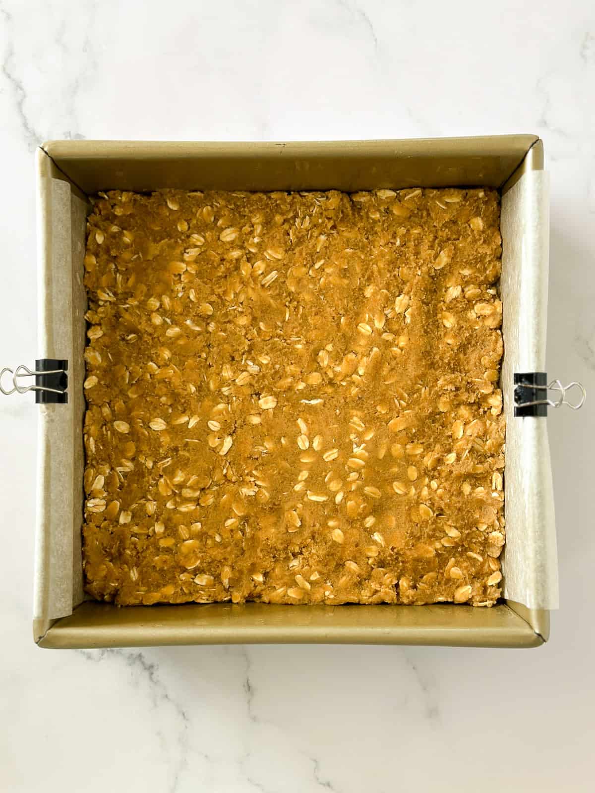 half the dough pressed on the bottom of there baking pan.