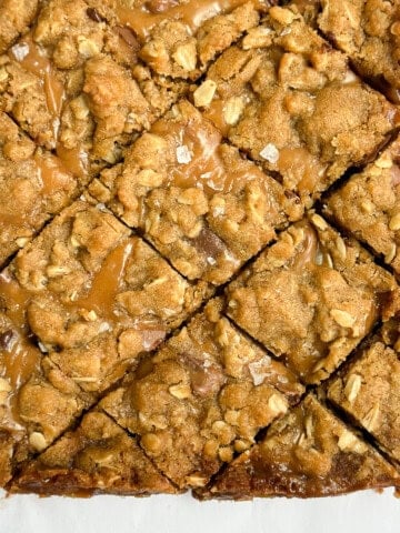 a close up of oatmeal carmelita toffee bars cut into squares.