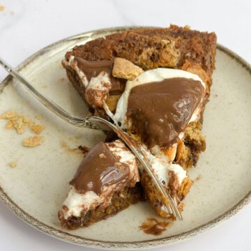 a single piece of the s'mores cookie cake with a fork cutting into it.