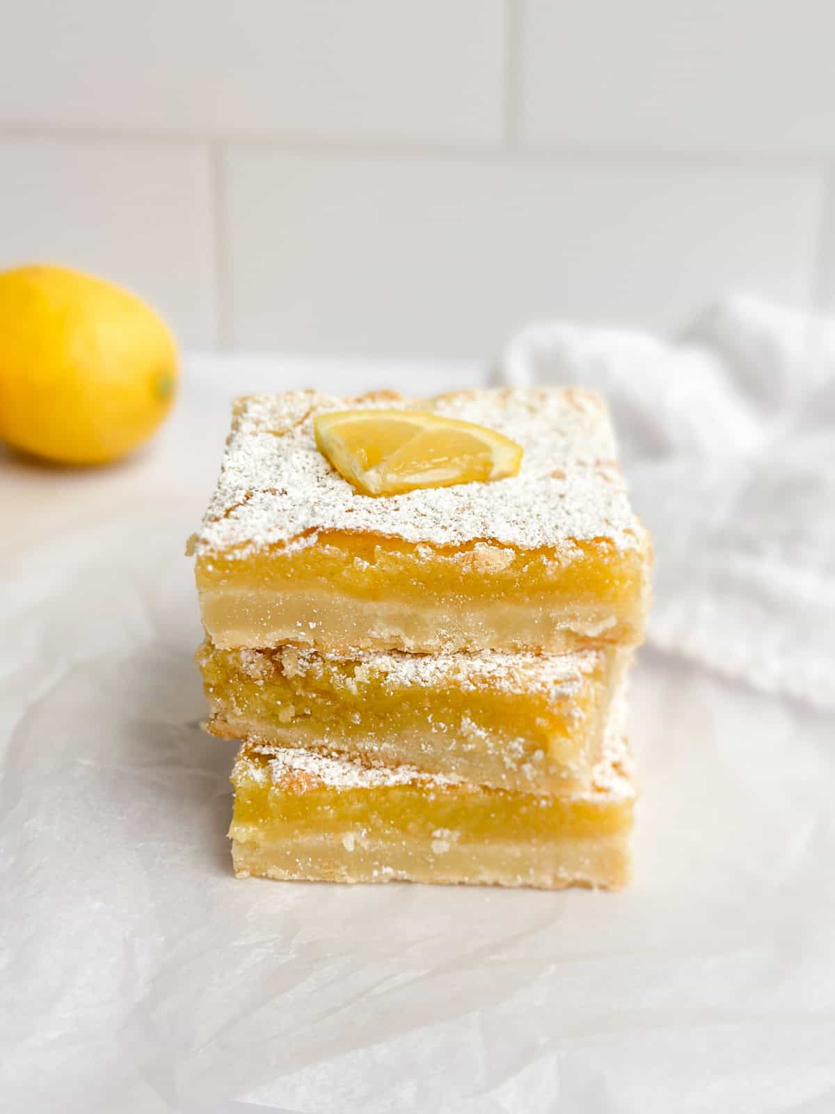 three easy homemade are lemon bars stacked on top of each other so you can see the inside texture.