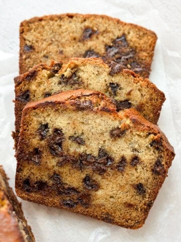 three slices of browned butter banana chocolate chip bread stacked on top of each other.