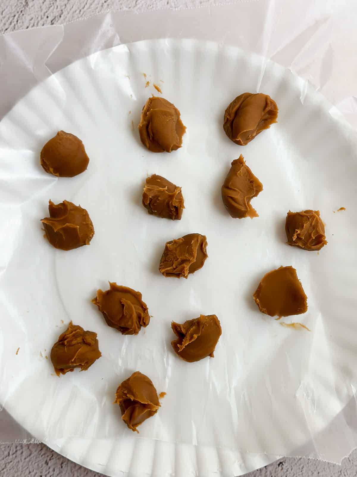 little balls of cookie butter on a plate to freeze.