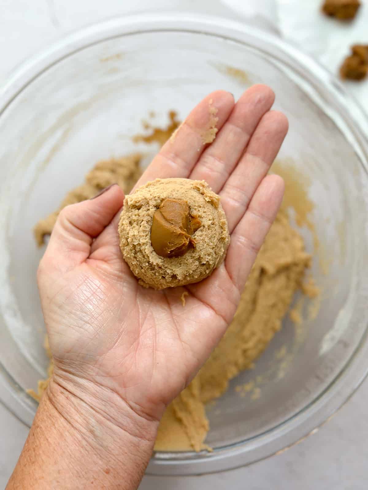 showing how to place the cookie butter ball inside the cookie dough.