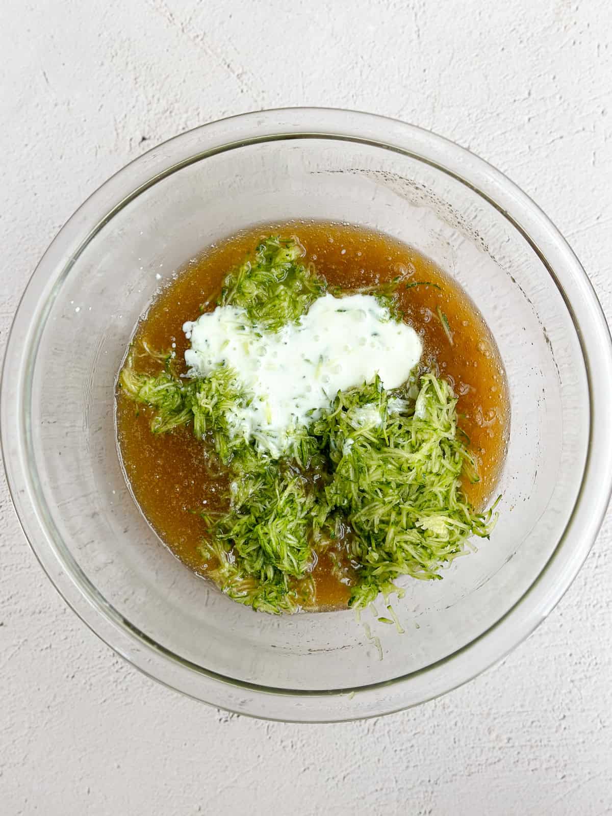 adding in the grated zucchini and the buttermilk.