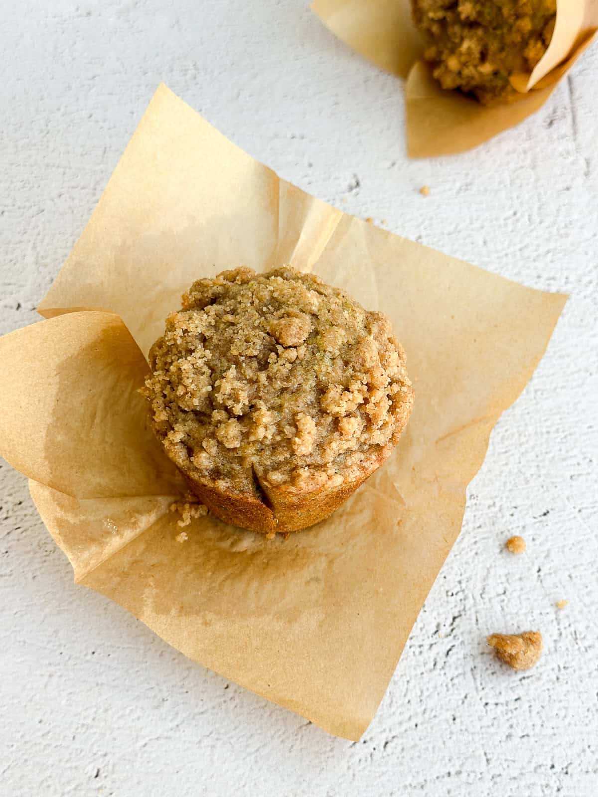a single muffin on a piece of parchment paper.