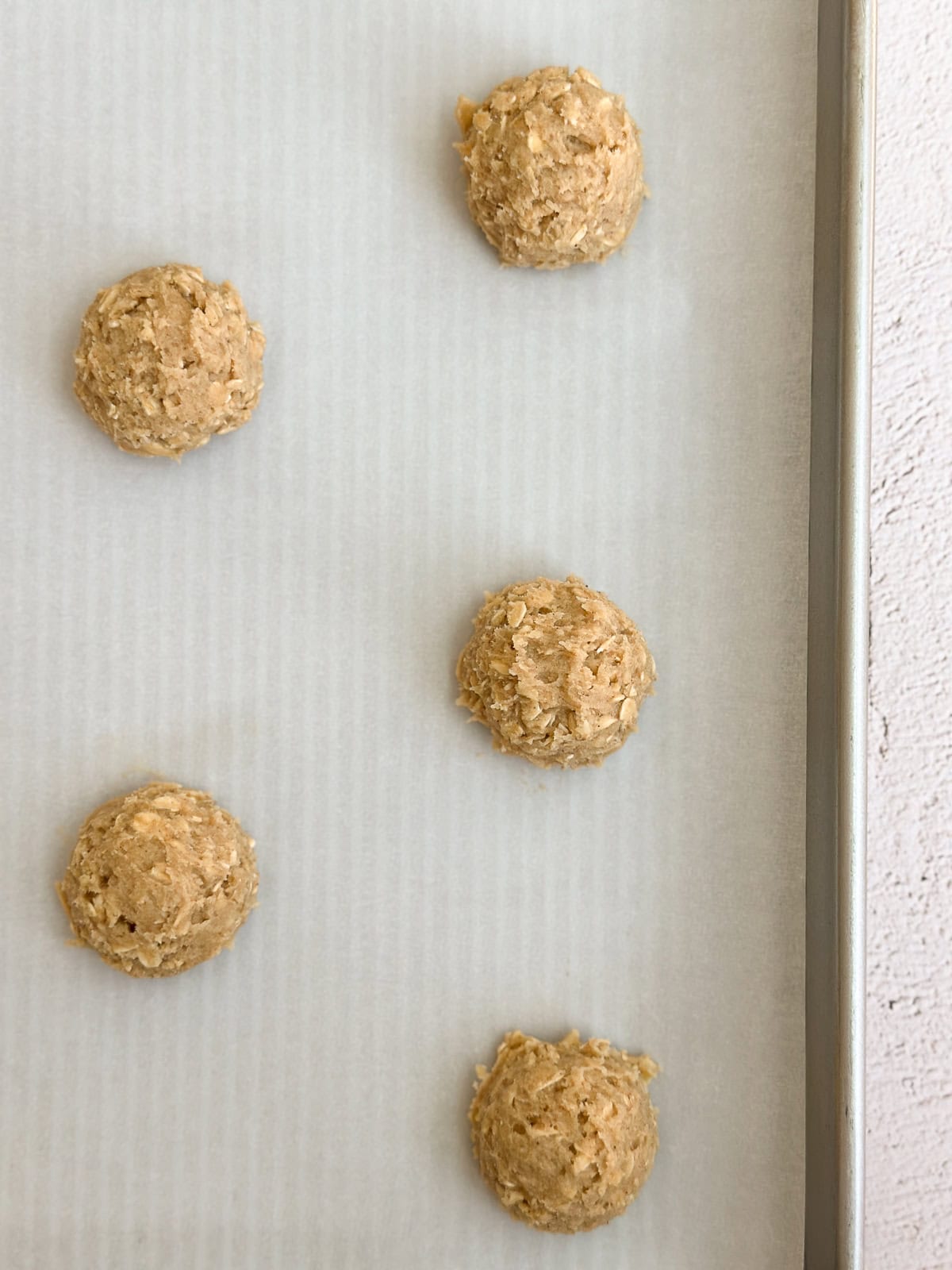 cookie dough balls on a cookie sheet.