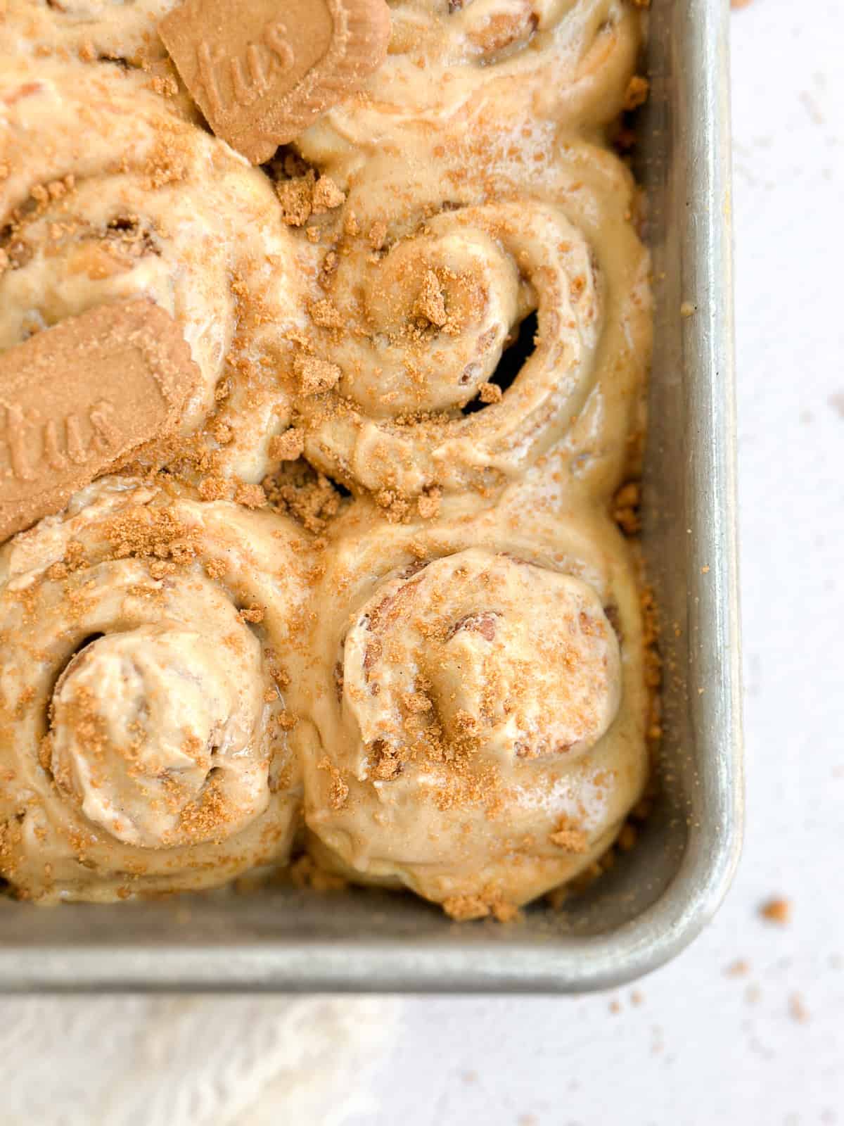 a close up of a few biscoff cinnamon rolls in the pan.