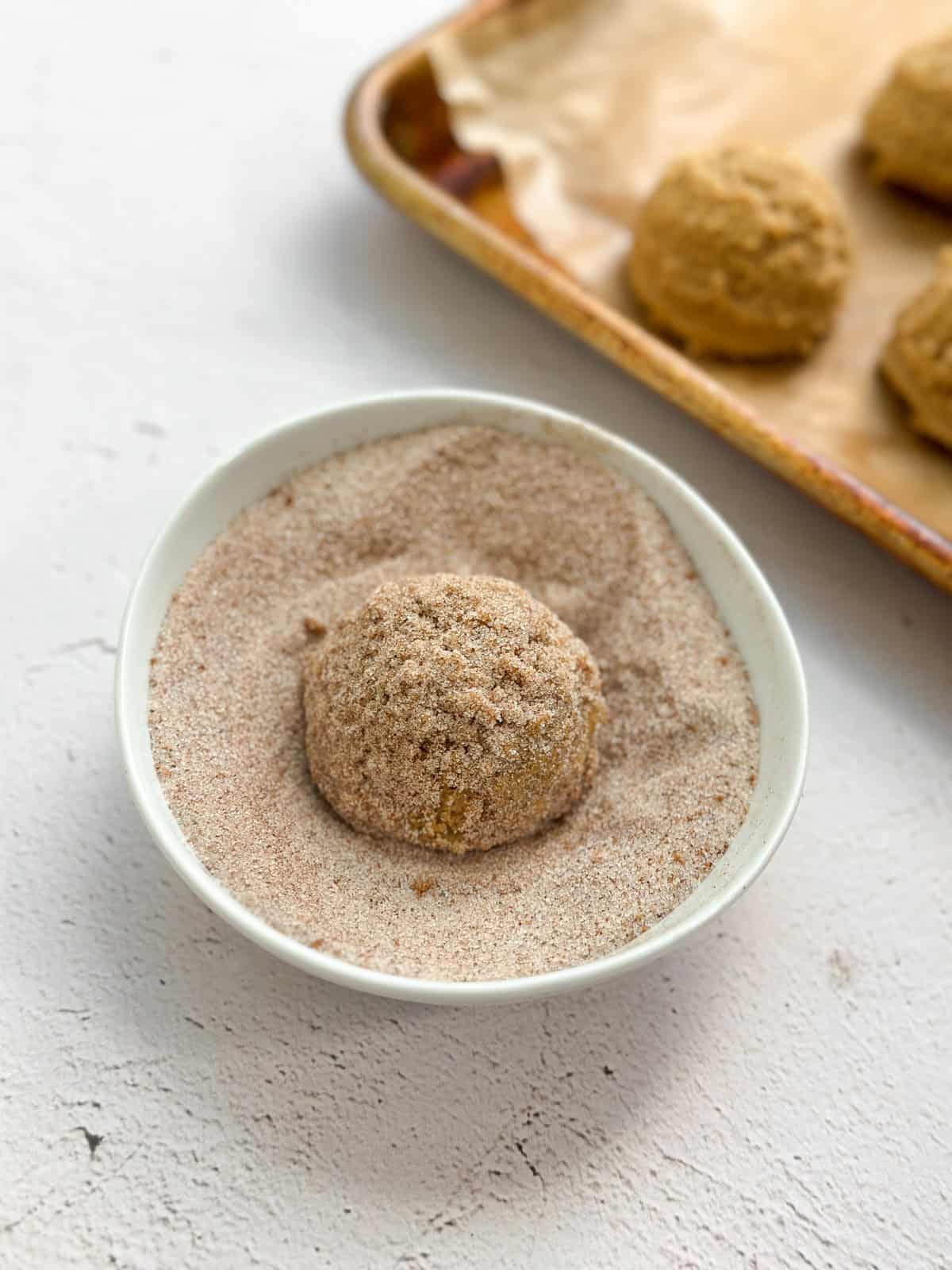 cookie ball in cinnamon sugar.