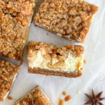 the apple crumble cheesecake bars sitting different directions to show the top layer and the inside layers.