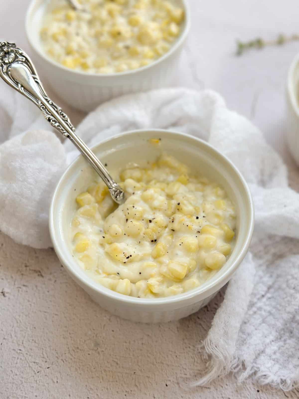 a bowl of easy cream corn with a spoon digging in.