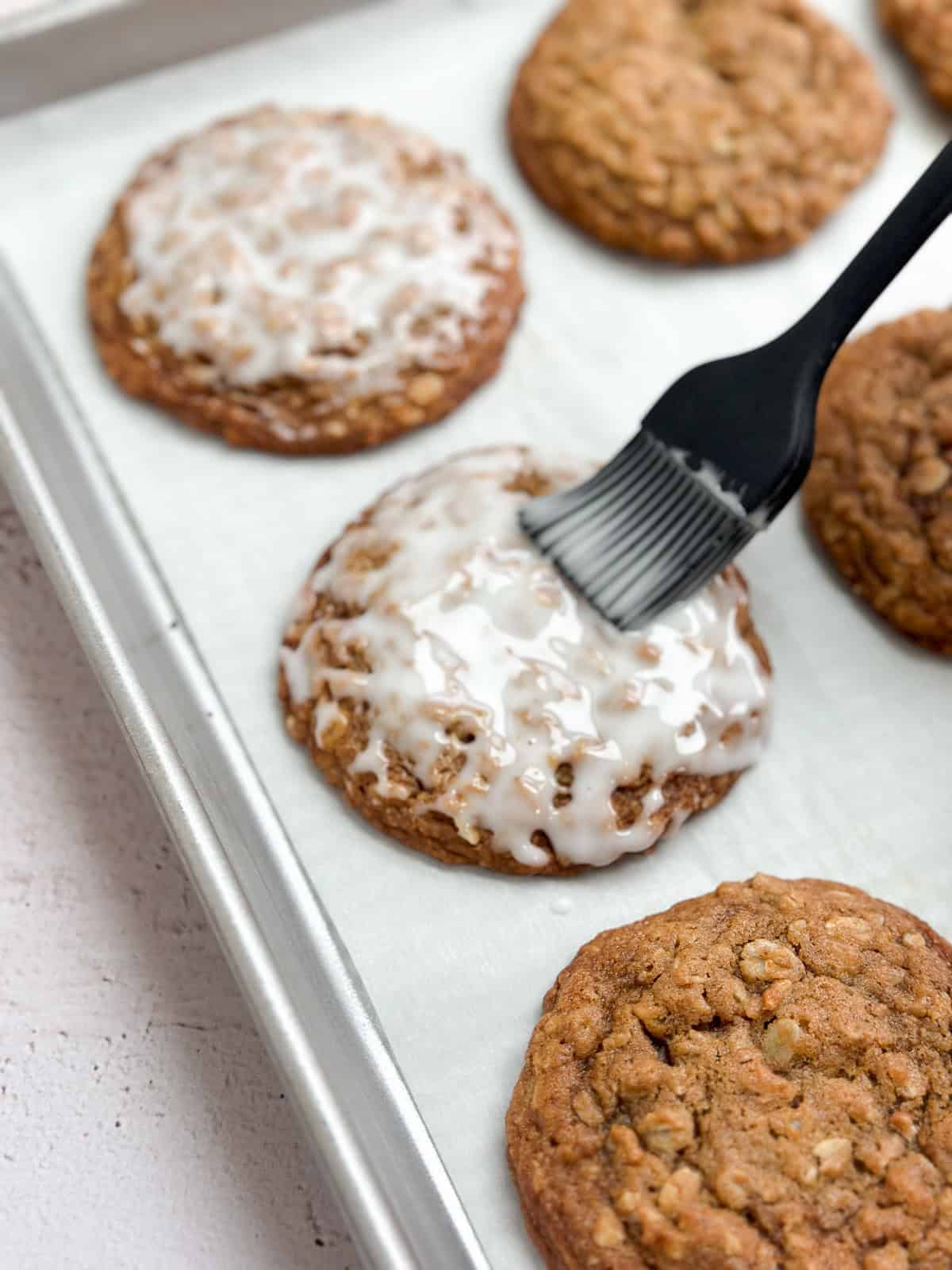 brushing a cookie with the lemon glaze.