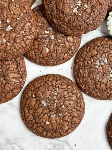 brownie crinkle cookies scattered with salt on the side.