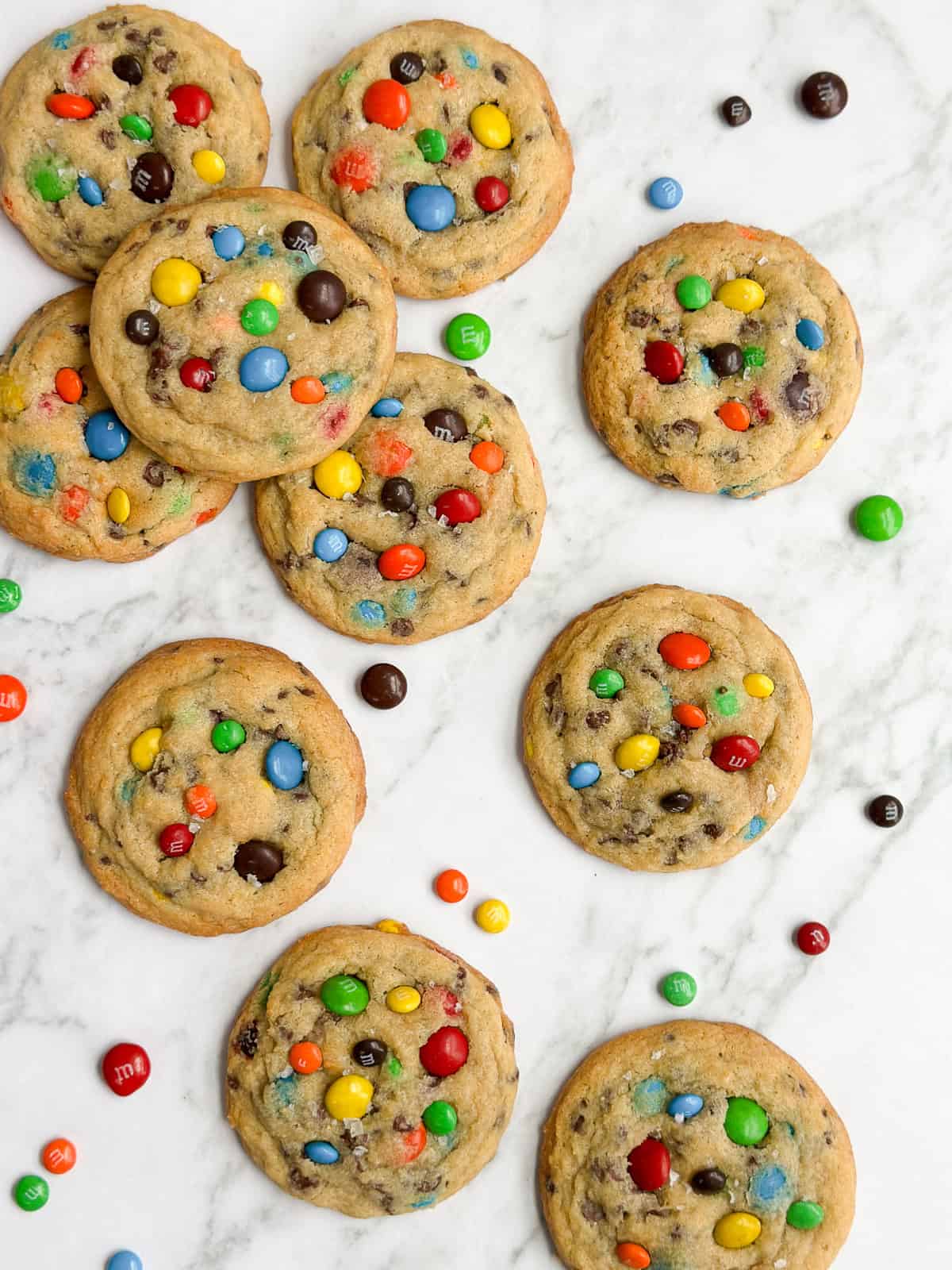 m&m chocolate chip cookies stacked with mini m&m's around them.
