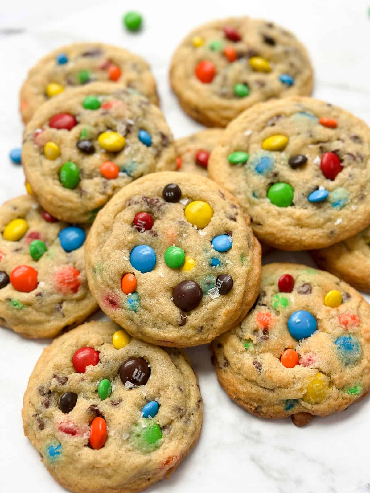 a bunch of m&m chocolate chip cookies stacked on top of each other.
