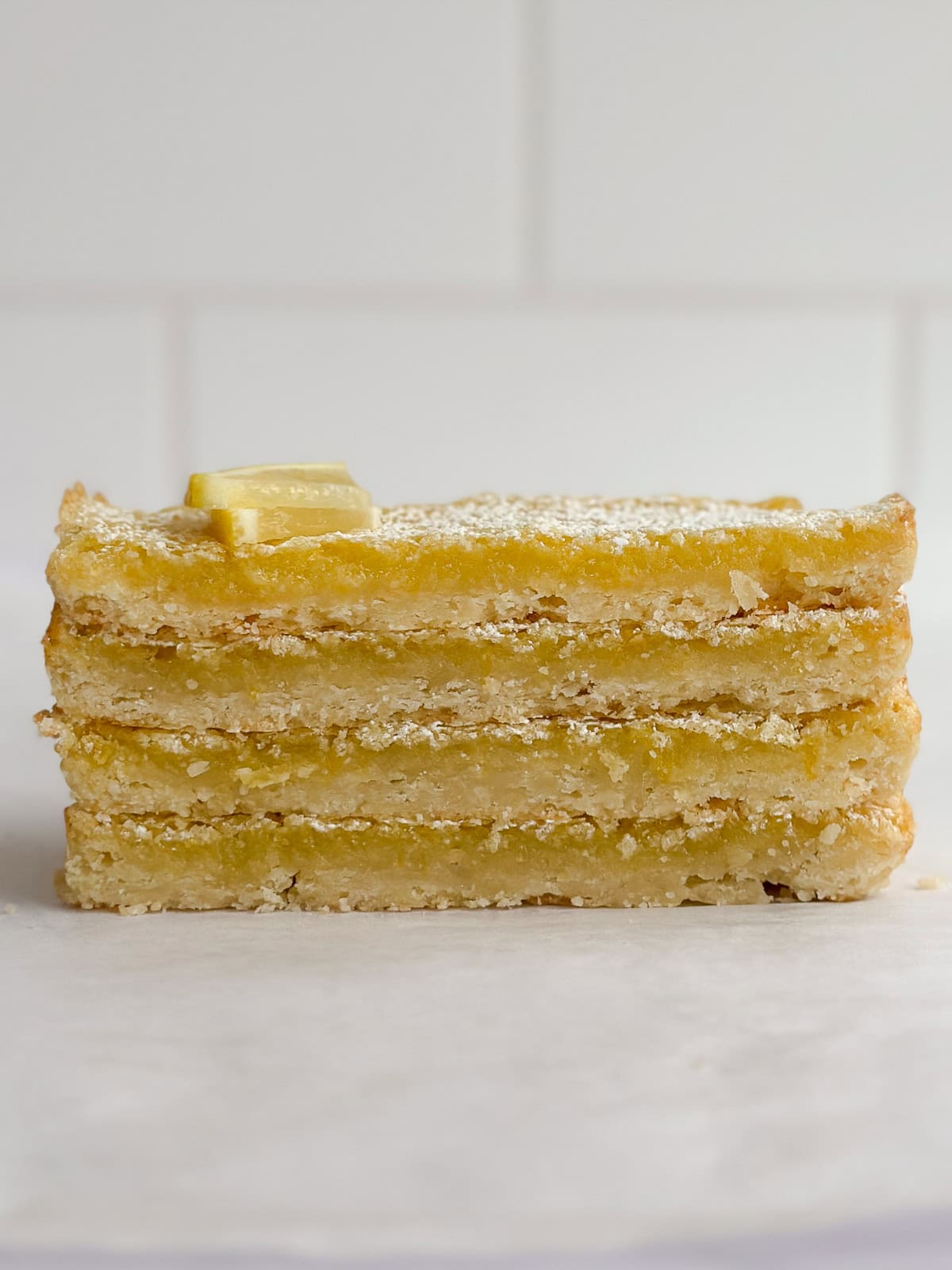 4 of the small batch lemon bars stacked on top of each other.