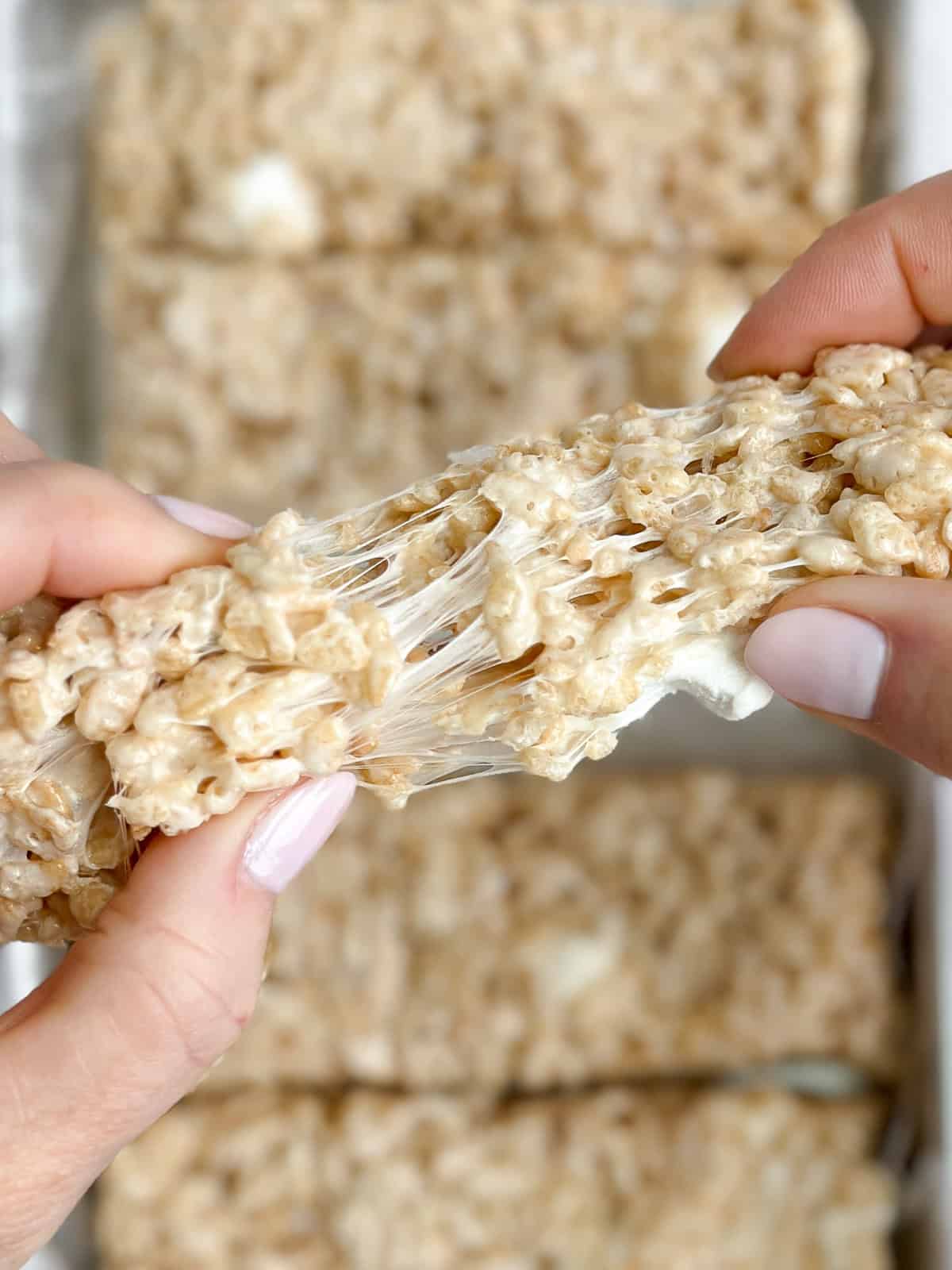 hands pulling the rice krispie treats apart.