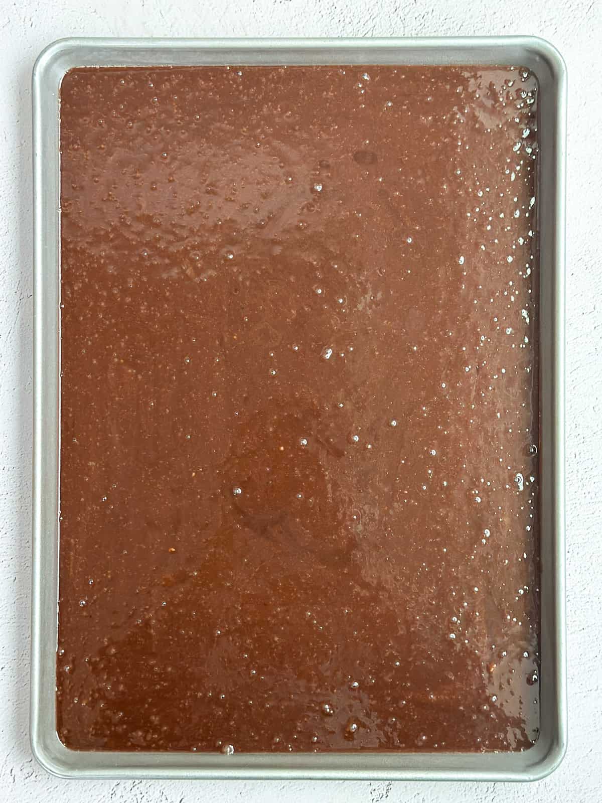 the cake batter poured into the sheet pan before baking.