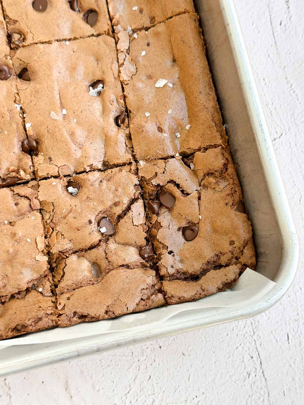 a close up of sheet pan brownies in the pan after cutting.
