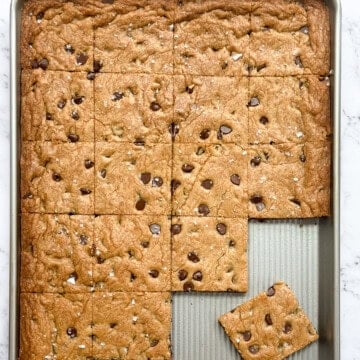 sheet pan chocolate chip cookie bars cut into squares on a sheet pan.