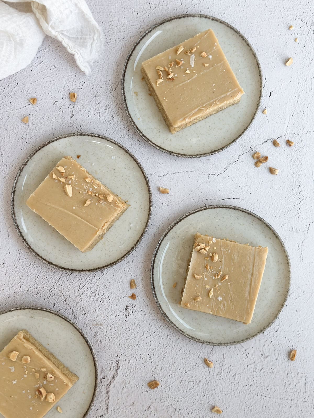4 slices of peanut butter sheet cake on different plates.