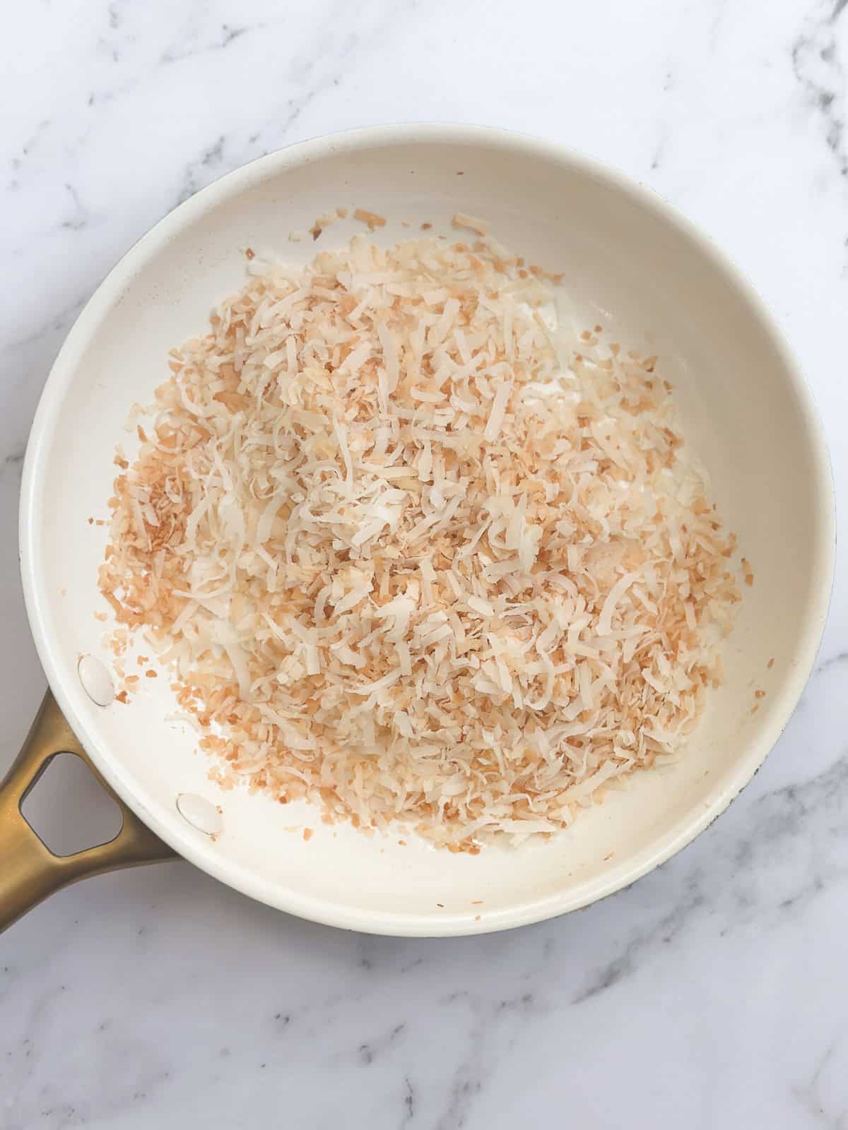toasted coconut in a frying pan.