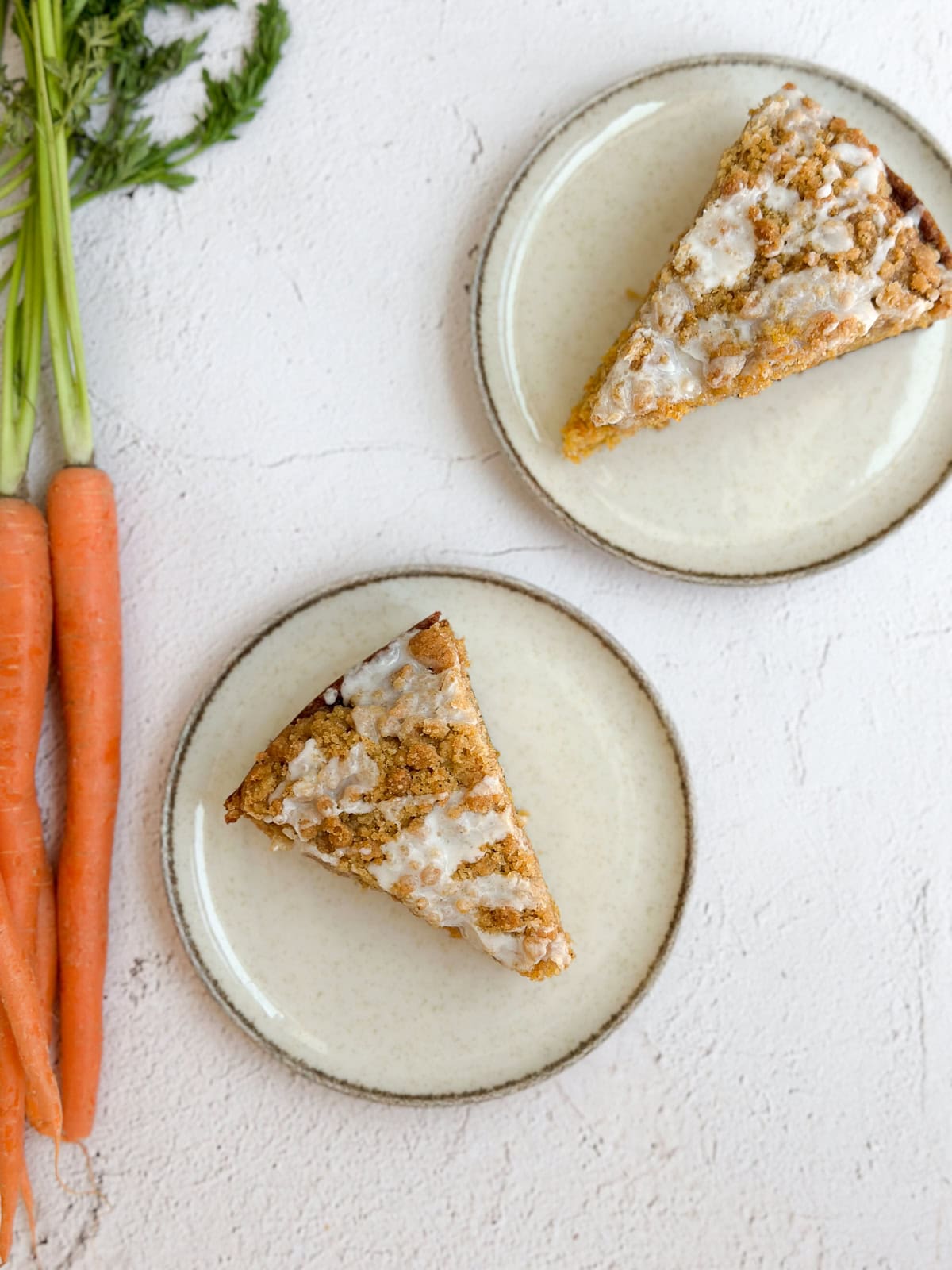 deux tranches de gâteau au café à la carotte avec quelques carottes à côté
