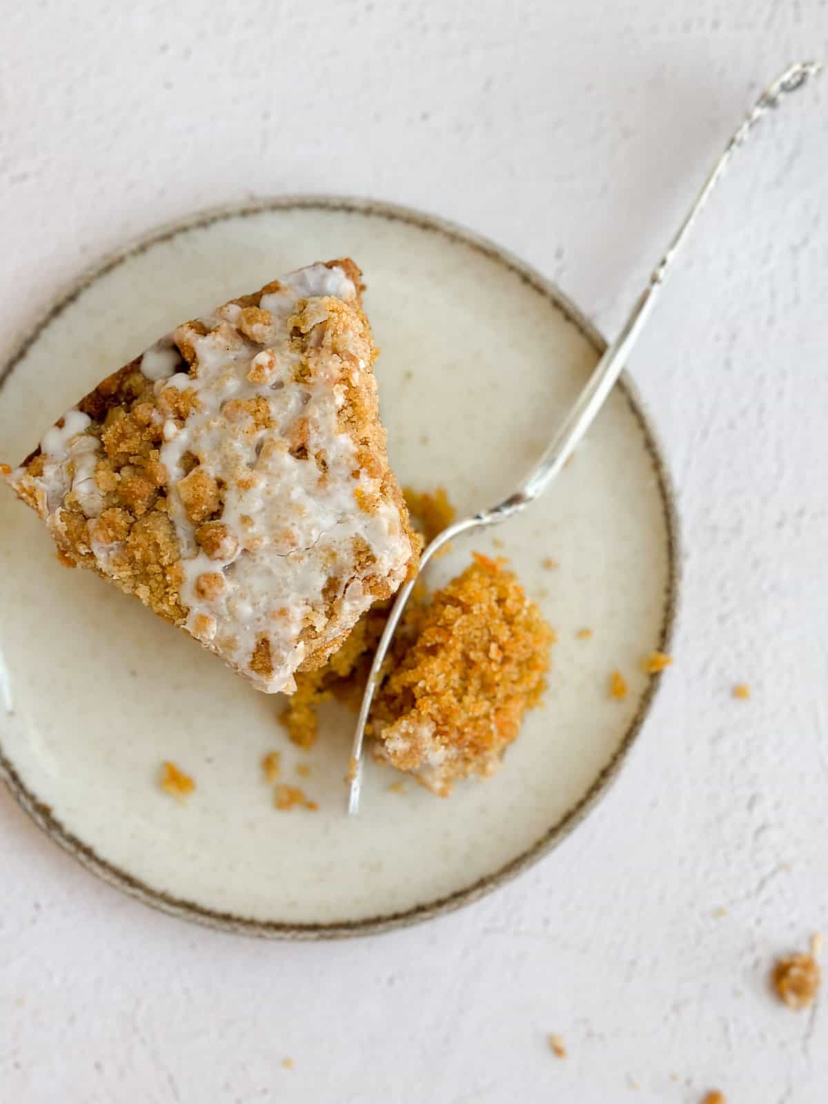 un morceau de gâteau au café à la carotte sur une assiette avec une fourchette coupant dedans