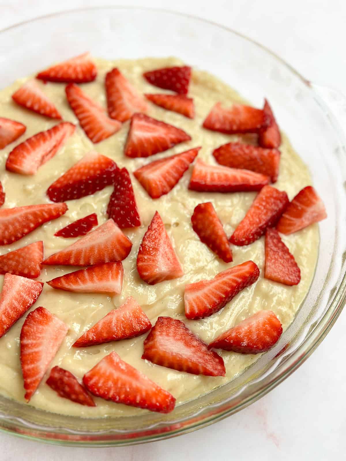 a close up of the strawberries on top of the cake before adding the streusel.