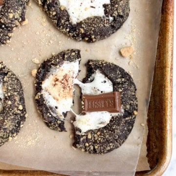 a few double chocolate s'more cookies with one broken, but marshmallow still attached.