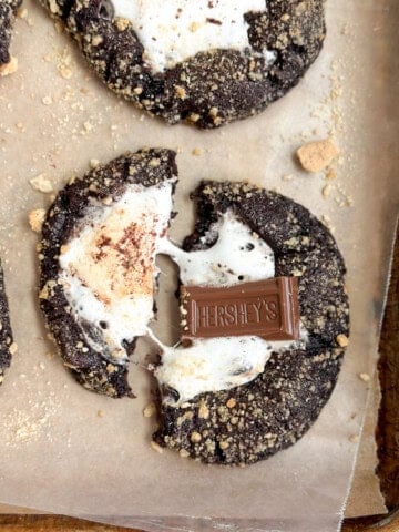 a few double chocolate s'more cookies with one broken, but marshmallow still attached.