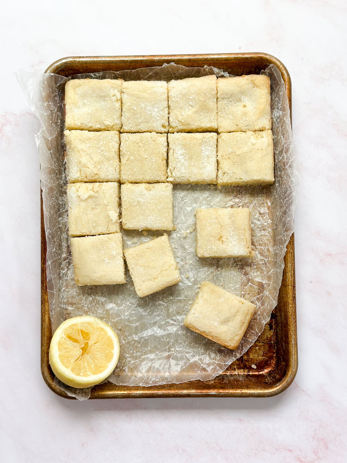 a bunch of lemon sugar cookie bars cut and in a pan.
