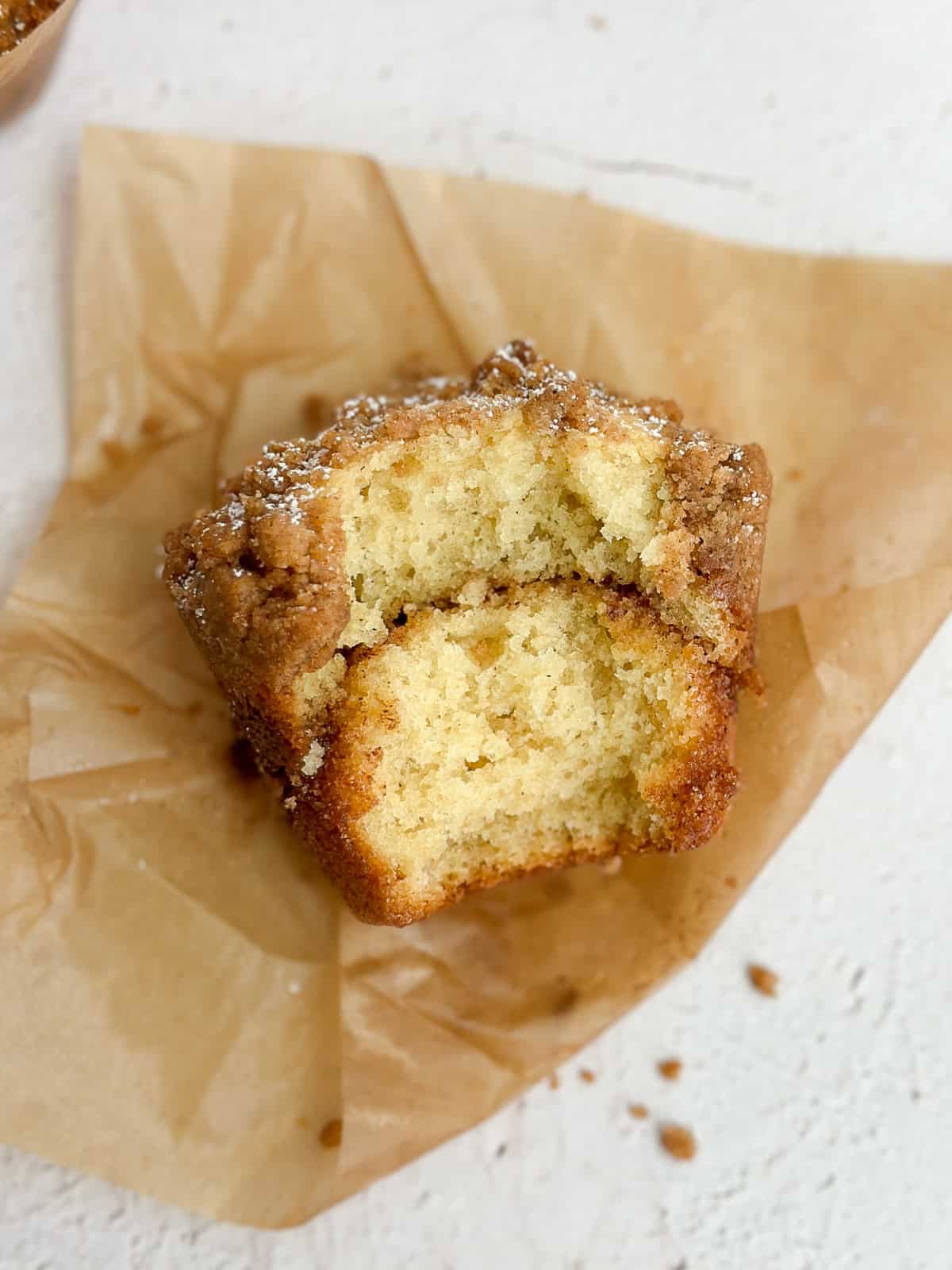 un muffin streusel à la cannelle avec une grande bouchée, révélant l'intérieur tourbillonnant de cannelle.