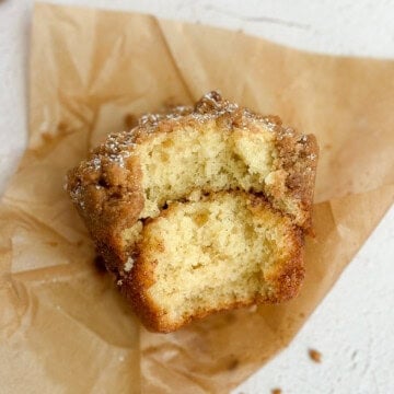 a cinnamon streusel muffin with a big bite out of it so you can see the cinnamon swirl inside.