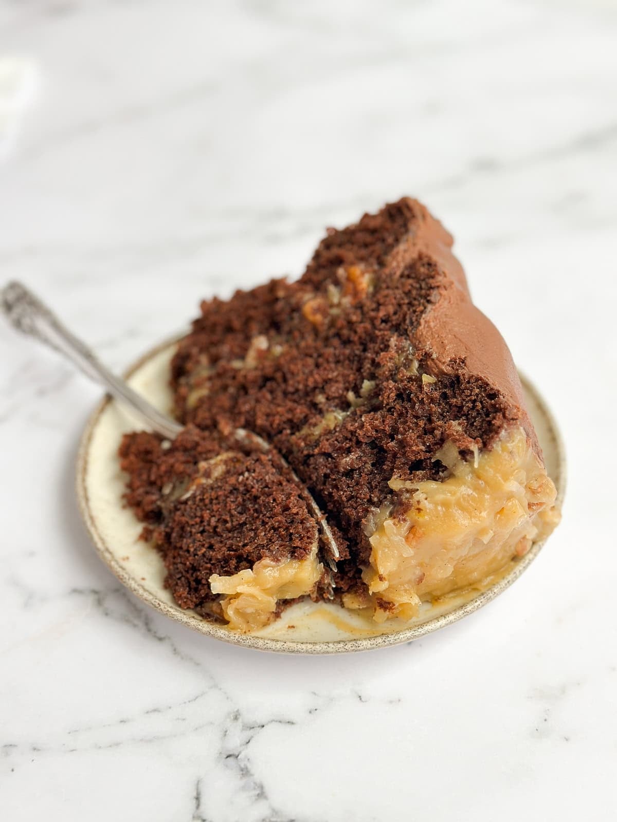 a slice of homemade german chocolate cake with a fork inside.