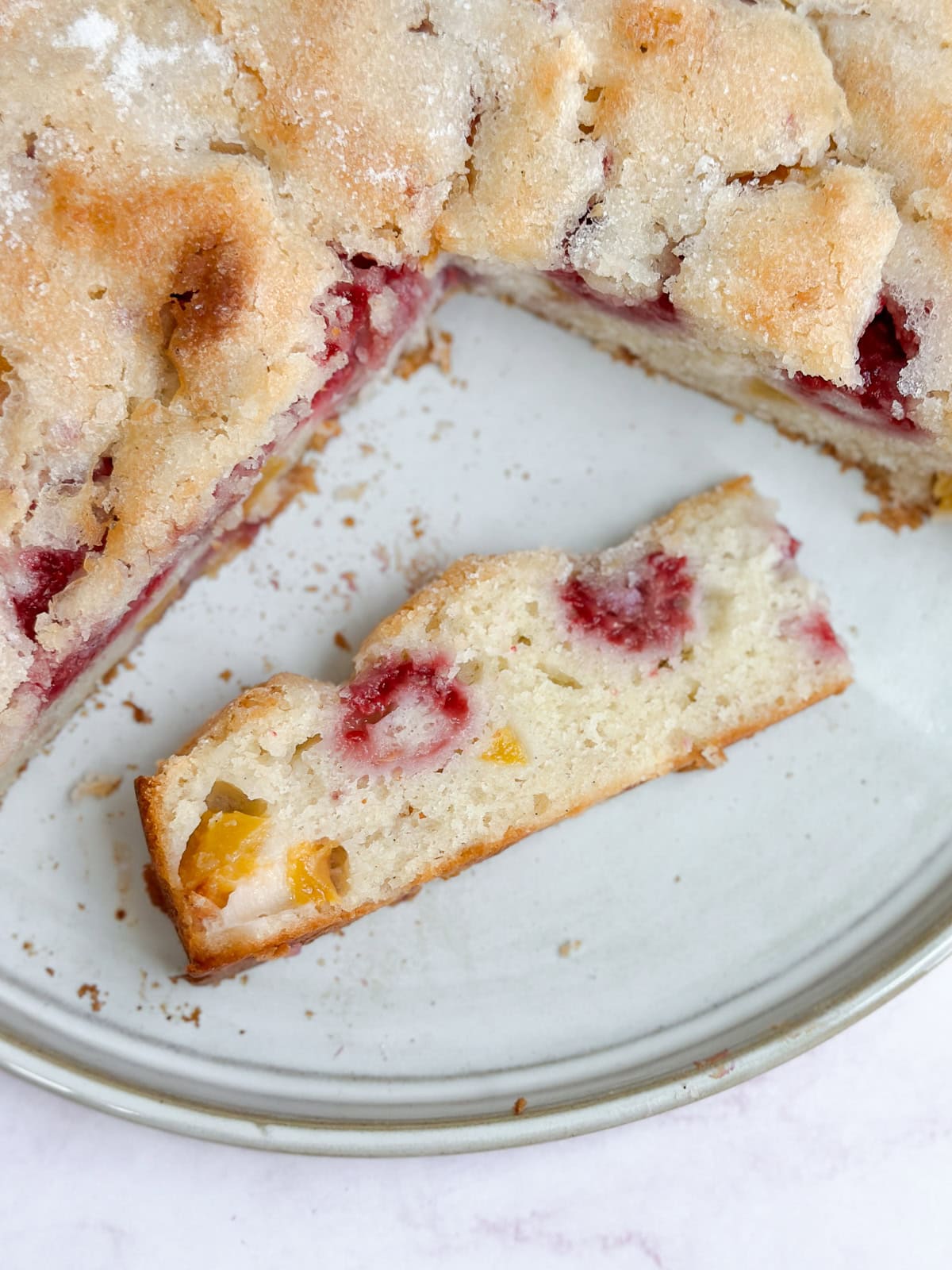 a slice or the raspberry peach cake on it's side to see the inside texture and fruit.